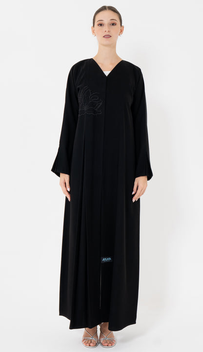 Black abaya worn by a model on a white background